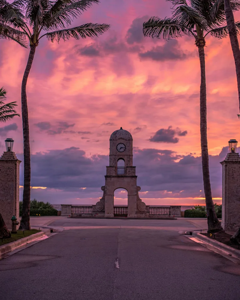 Worth Avenue Clock Tower at sunset framed by palm trees, Palm Beach